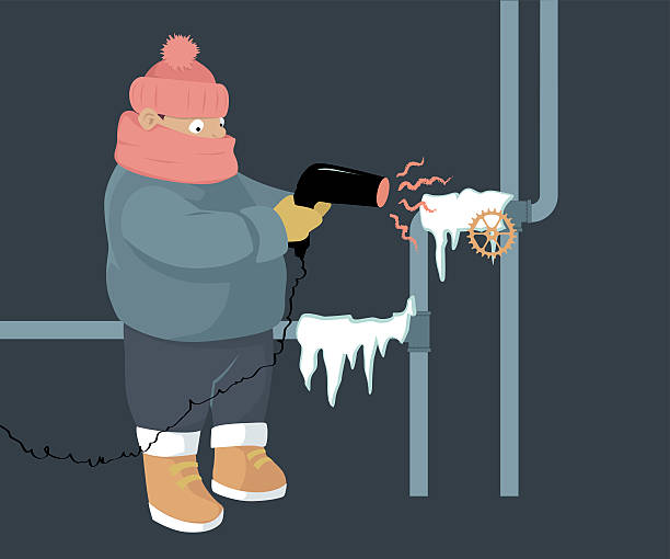 A person attempting to unfreeze frozen water pipes with a hair dryer