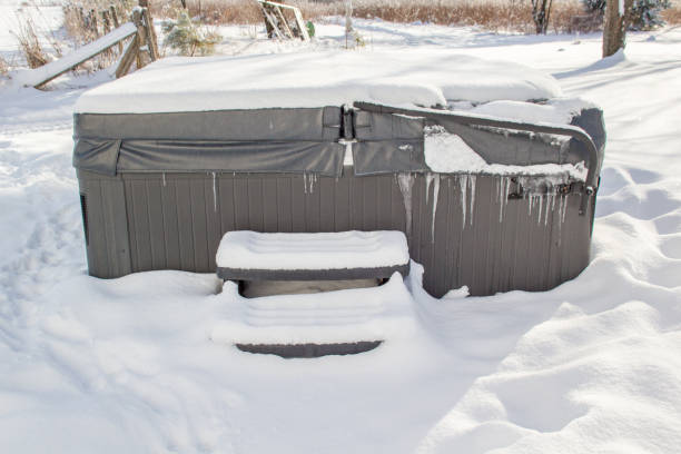 Covered outdoor hot tub surrounded by snow and with hanging ice.